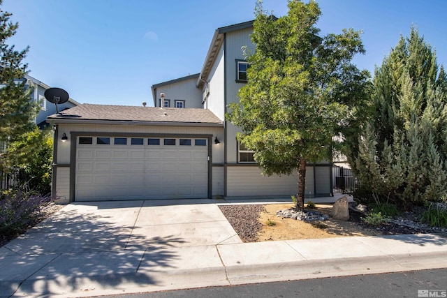 view of front of house with a garage, driveway, and fence