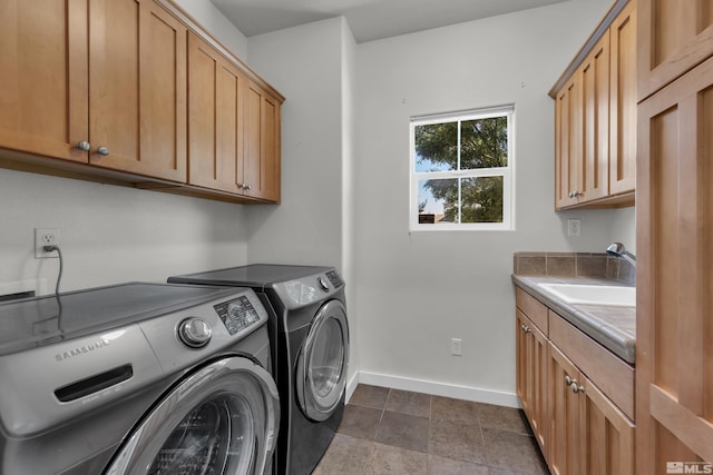 washroom featuring sink, washer and clothes dryer, and cabinets