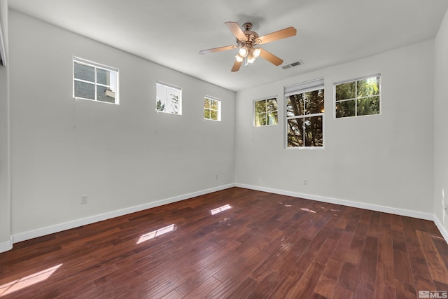 unfurnished room featuring dark wood-type flooring, ceiling fan, and plenty of natural light