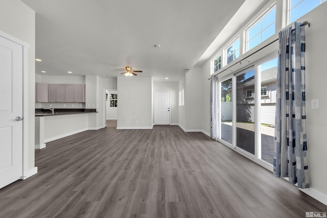 unfurnished living room featuring ceiling fan, hardwood / wood-style floors, and sink