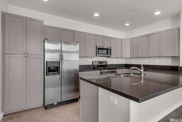 kitchen with sink, a center island with sink, gray cabinets, and appliances with stainless steel finishes