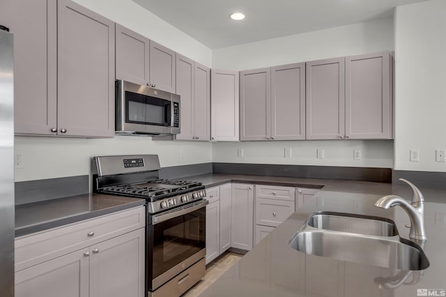 kitchen featuring stainless steel appliances, gray cabinets, and sink