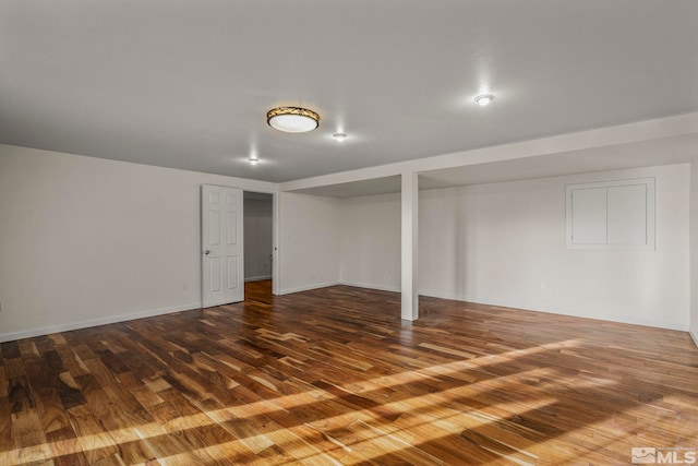 finished below grade area featuring baseboards and wood finished floors