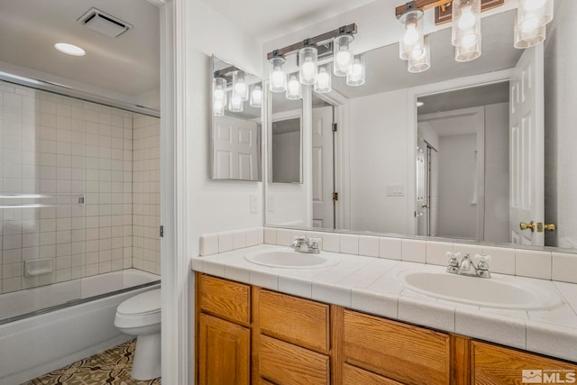 full bathroom featuring toilet, double vanity, a sink, and visible vents