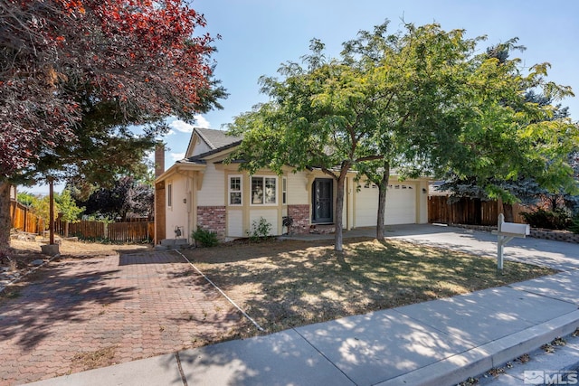 view of front of house with concrete driveway, brick siding, an attached garage, and fence