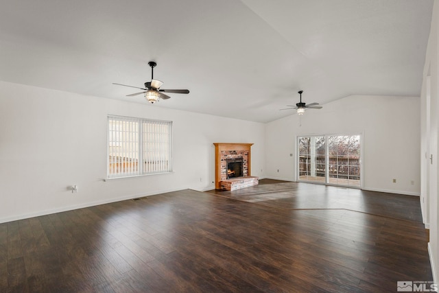 unfurnished living room featuring lofted ceiling, ceiling fan, wood finished floors, baseboards, and a brick fireplace