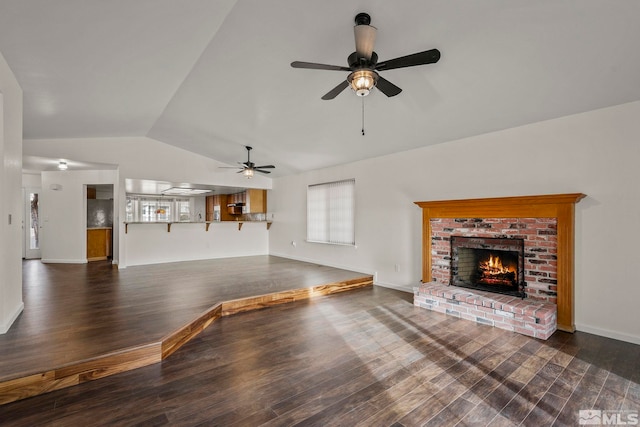 unfurnished living room featuring ceiling fan, lofted ceiling, a fireplace, and wood finished floors