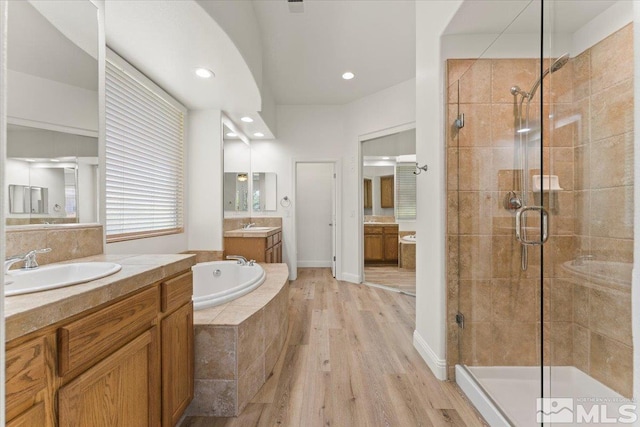 bathroom featuring hardwood / wood-style floors, separate shower and tub, and vanity