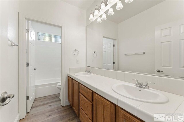 full bathroom featuring hardwood / wood-style floors, toilet, bathtub / shower combination, and vanity