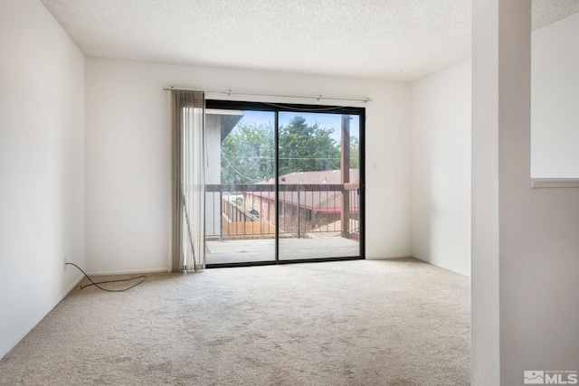 carpeted spare room with a textured ceiling