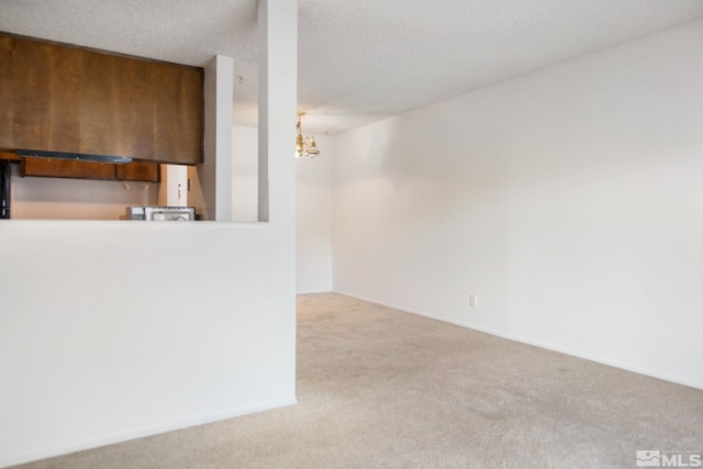 kitchen featuring a textured ceiling, carpet floors, and a chandelier