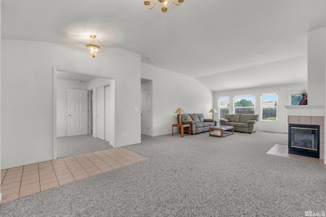 living area featuring lofted ceiling, a chandelier, carpet floors, a fireplace, and tile patterned floors