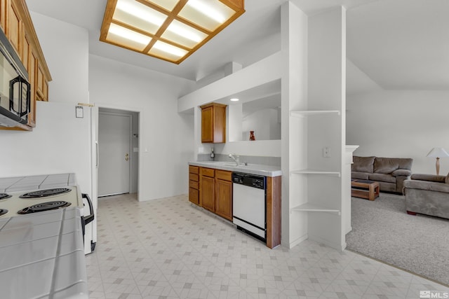 kitchen featuring a sink, light floors, black microwave, and dishwasher