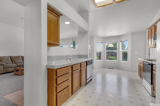 kitchen featuring dishwasher, electric range oven, open floor plan, black microwave, and a sink