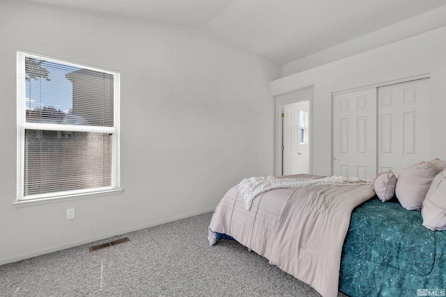 bedroom featuring visible vents, baseboards, carpet, vaulted ceiling, and a closet