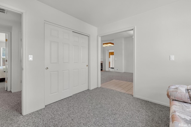 unfurnished bedroom with carpet flooring, visible vents, and baseboards