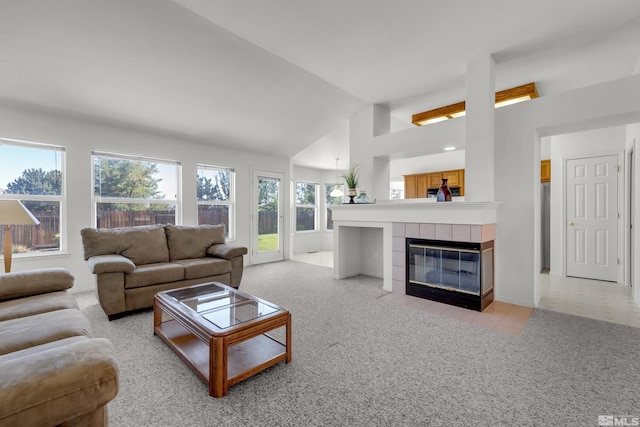 living area featuring a fireplace, vaulted ceiling, and light colored carpet