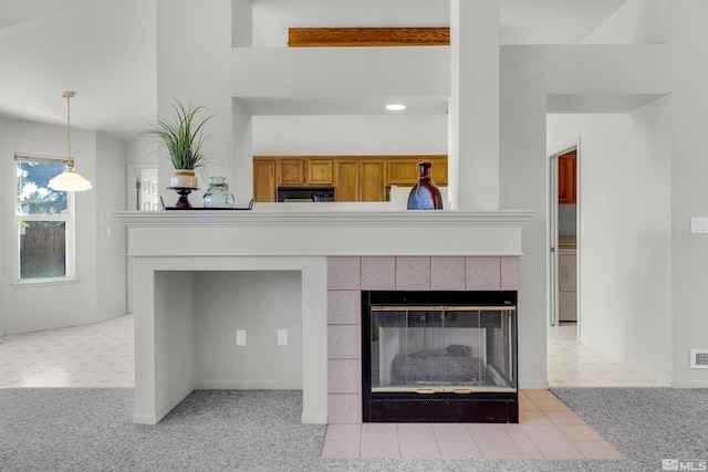 room details featuring visible vents, a fireplace, carpet flooring, and washer / dryer