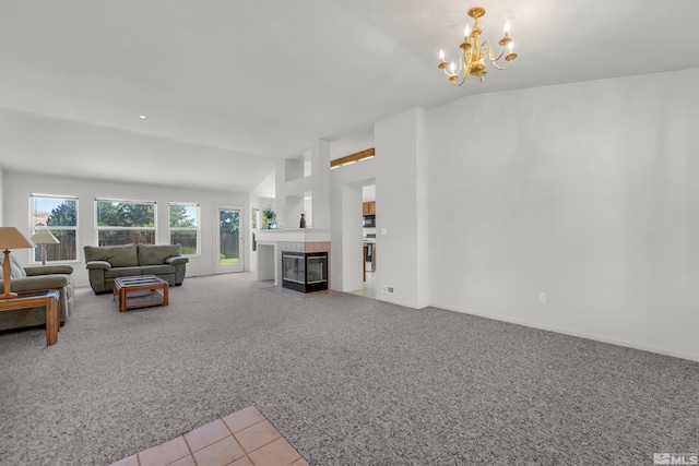 carpeted living area with vaulted ceiling, a tiled fireplace, tile patterned floors, and a notable chandelier