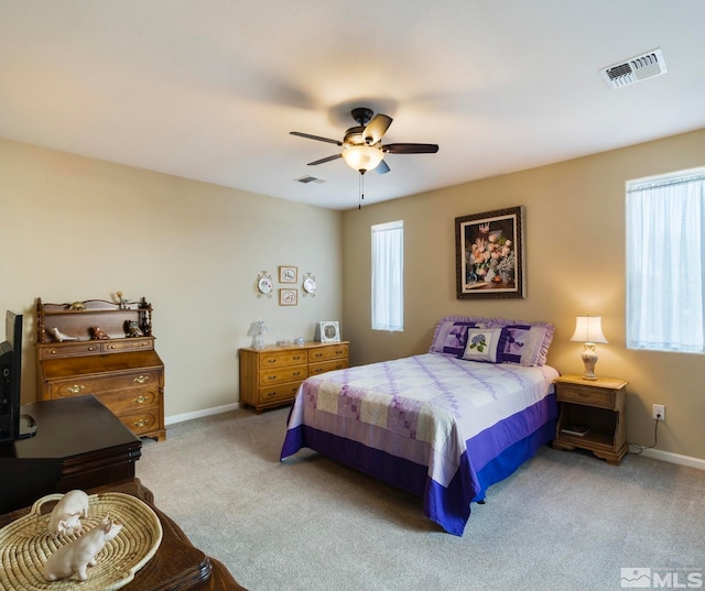 bedroom featuring carpet flooring, ceiling fan, and multiple windows