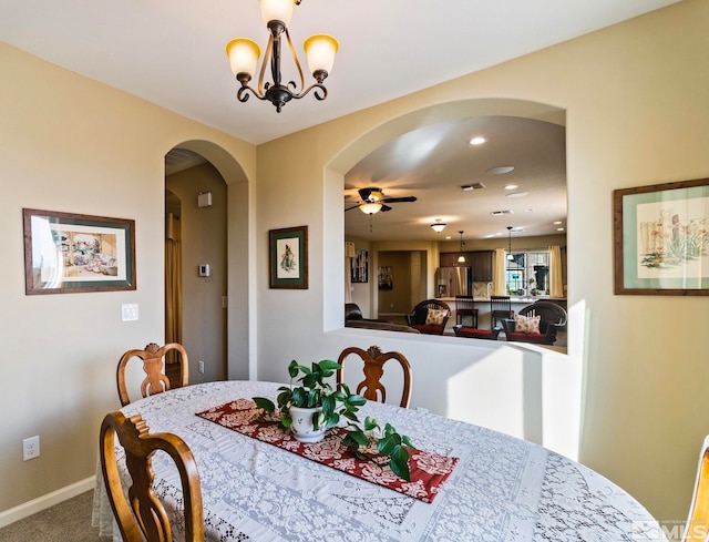 dining room with ceiling fan with notable chandelier and carpet floors