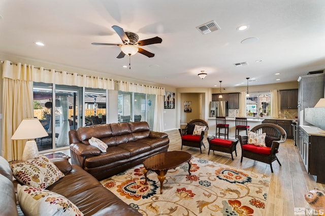 living room with ceiling fan and light hardwood / wood-style floors