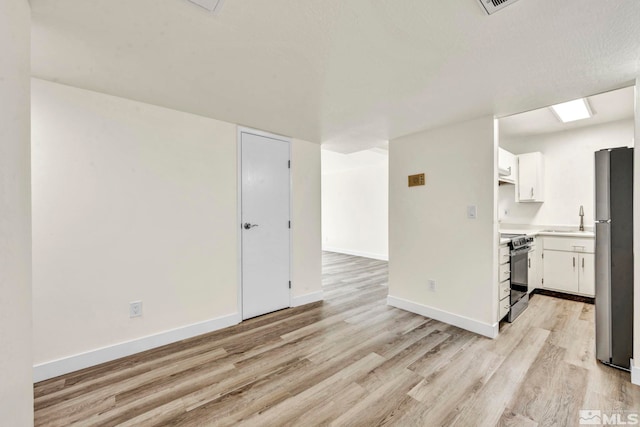 unfurnished living room with light wood-type flooring and sink