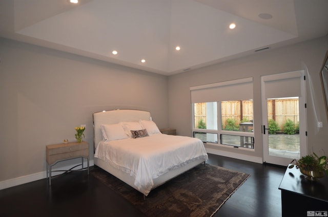 bedroom with a raised ceiling, visible vents, dark wood-type flooring, access to outside, and baseboards