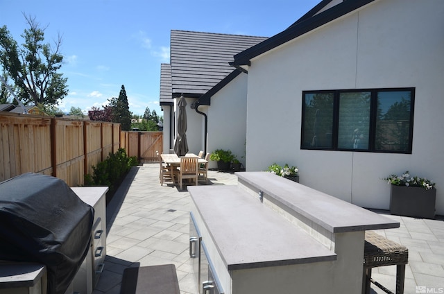 view of patio / terrace featuring a fenced backyard, grilling area, and outdoor dining space