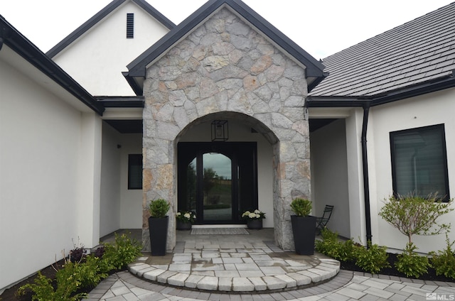 entrance to property with stone siding and stucco siding