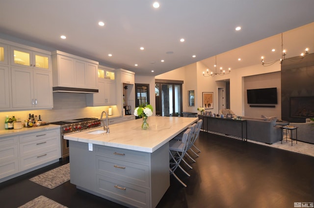 kitchen featuring open floor plan, high end stainless steel range oven, a sink, and recessed lighting