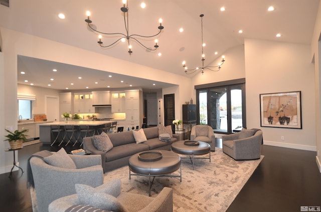 living room with high vaulted ceiling, a chandelier, dark wood-type flooring, and recessed lighting