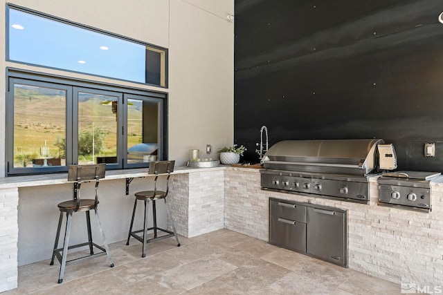 view of patio / terrace featuring area for grilling, an outdoor kitchen, and french doors