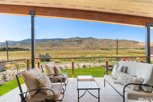 view of patio / terrace with a mountain view, an outdoor living space, and a rural view