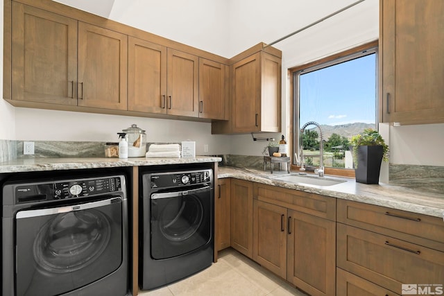 laundry room featuring light tile patterned floors, cabinets, separate washer and dryer, and sink