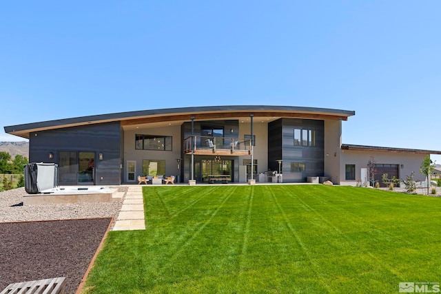 rear view of house with a lawn and a patio