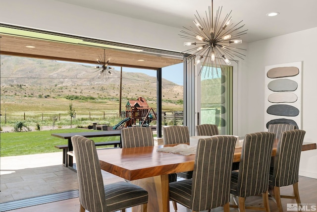 dining space featuring a mountain view, hardwood / wood-style flooring, and a chandelier