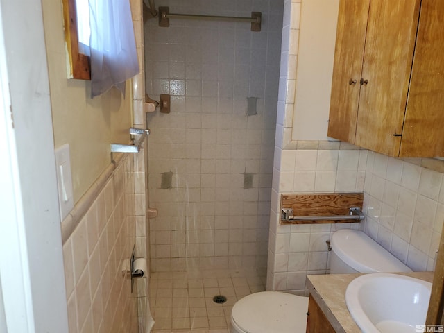 bathroom with tiled shower, toilet, tile walls, and vanity