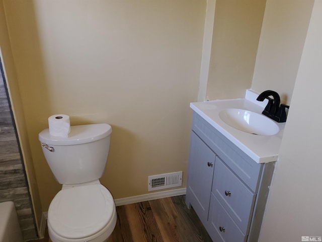 bathroom with toilet, hardwood / wood-style flooring, and vanity