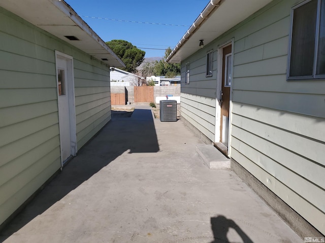 view of side of home with central AC and a patio