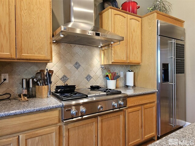 kitchen featuring backsplash, stainless steel appliances, and wall chimney range hood