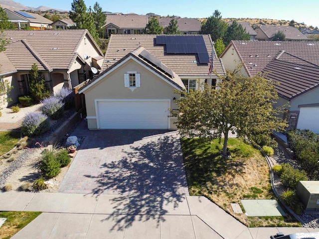 view of front of property featuring solar panels and a garage