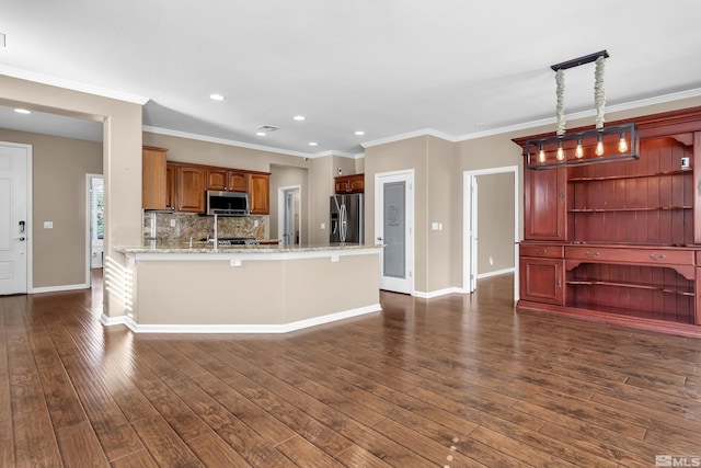 kitchen featuring pendant lighting, crown molding, dark hardwood / wood-style flooring, light stone counters, and appliances with stainless steel finishes