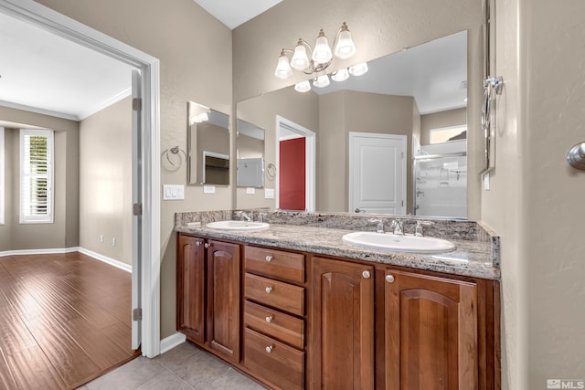 bathroom with crown molding, vanity, and wood-type flooring