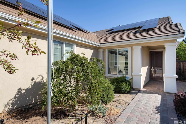 view of exterior entry featuring solar panels