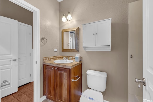 bathroom with vanity, toilet, and hardwood / wood-style floors