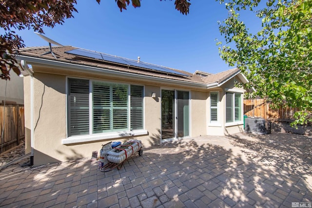 back of property featuring a patio area and solar panels