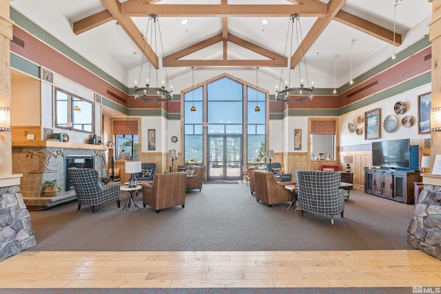 living room with high vaulted ceiling, hardwood / wood-style flooring, a chandelier, and beamed ceiling