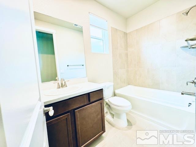 full bathroom with tiled shower / bath, vanity, and toilet