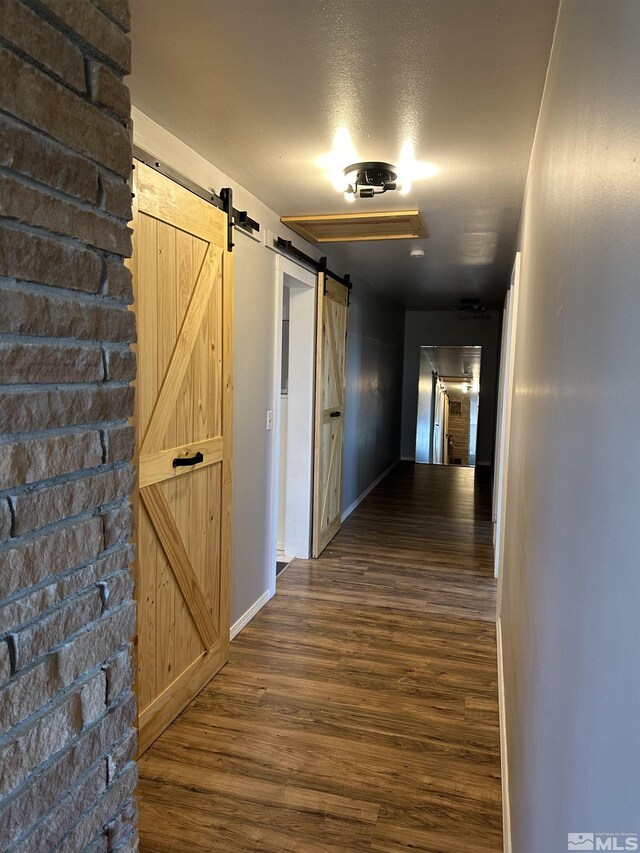 hallway featuring a barn door and hardwood / wood-style flooring